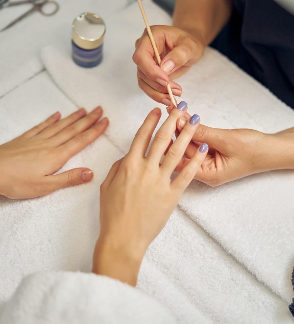 Beauty professional doing colour manicure for lady